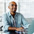A businessman smiles and speaks with a customer.